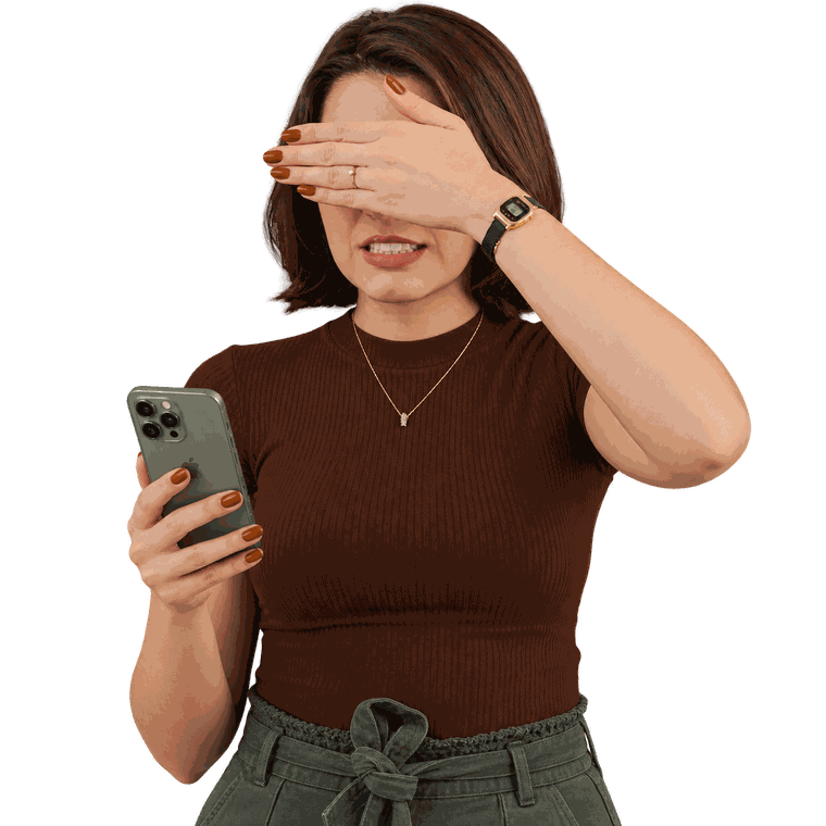 Mulher cobrindo os olhos com a mão enquanto olha o celular